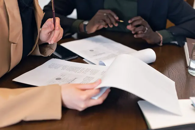 Professionals reviewing corporate documents during a meeting