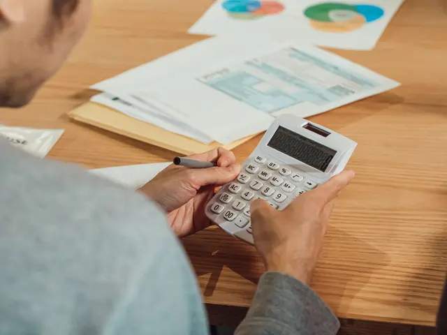 An accountant using a calculator alongside financial records