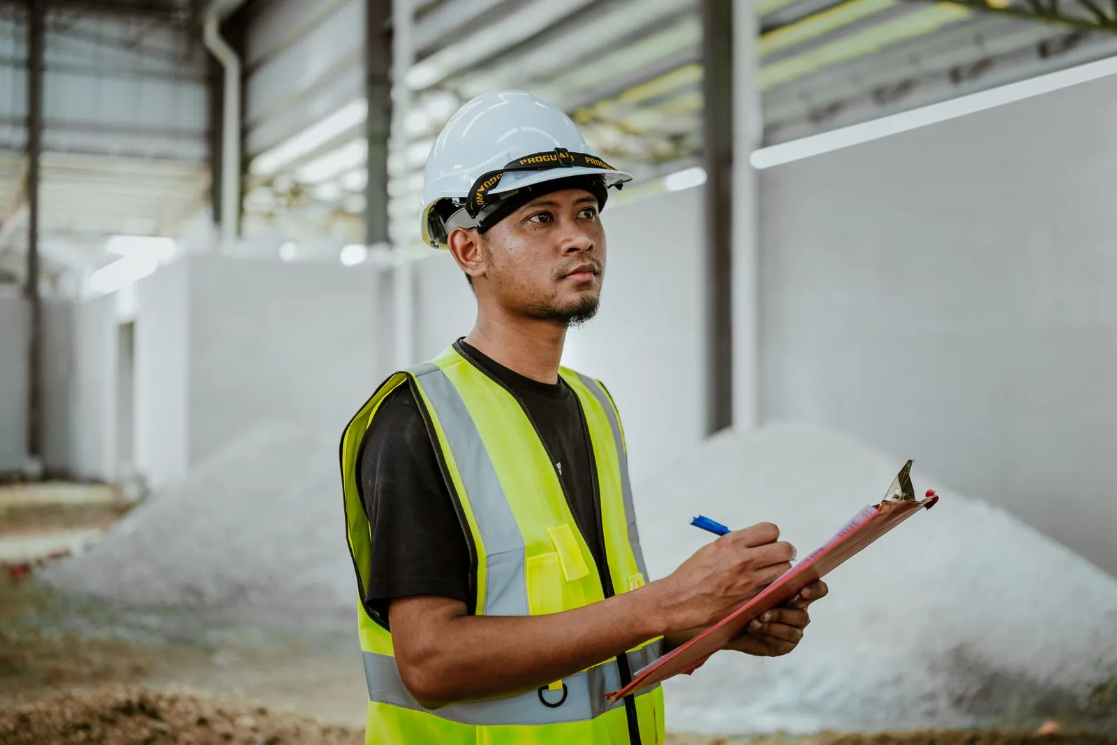 A workplace supervisor reviewing inspection records on a clipboard
