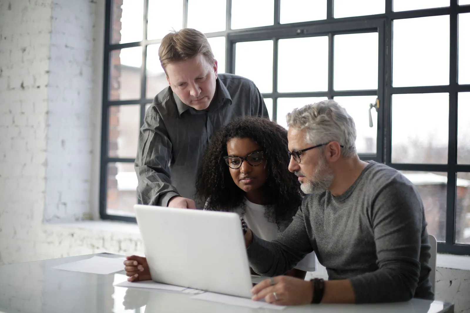 A startup team collaborating on a laptop in a bright workspace